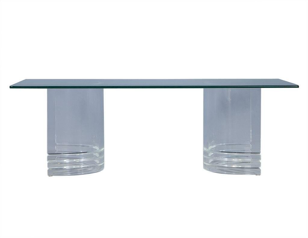 This Mid-Century Modern cocktail table is the definition of unique. It is comprised of Lucite half-moon pedestals that can be freely adjusted below the rectangular glass top. This piece with its light elegance is a perfect addition to any space.