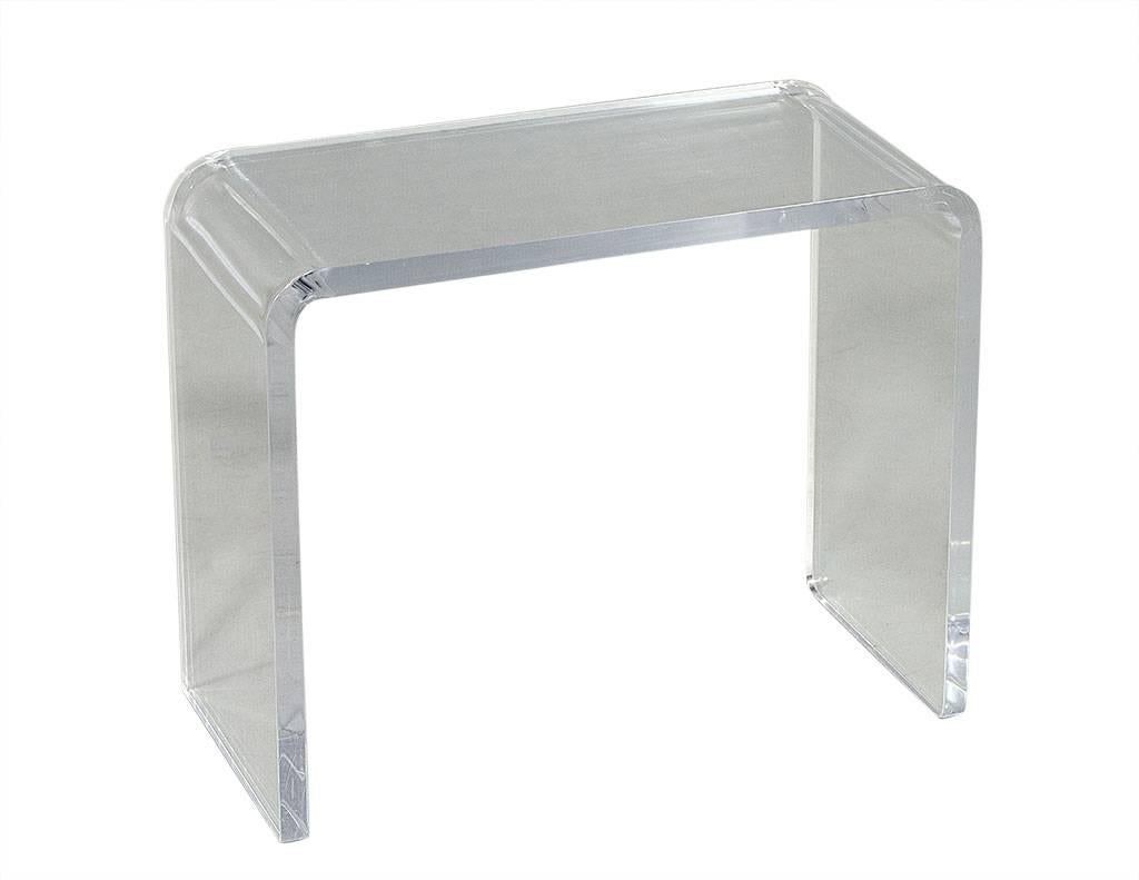 This distinctive Mid-Century Modern side table is narrow, waterfall-shaped, and made of thick Lucite acrylic. It harkens back to the 1970s and will bring style and cheer to any living area.