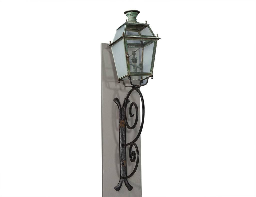 These Victorian style street lanterns are absolutely stunning. They are crafted out of iron and glass and mounted on wooden bases. The glass is frosted on the side panels, and there are decorative finials on the bottom. A little touch of Paris for