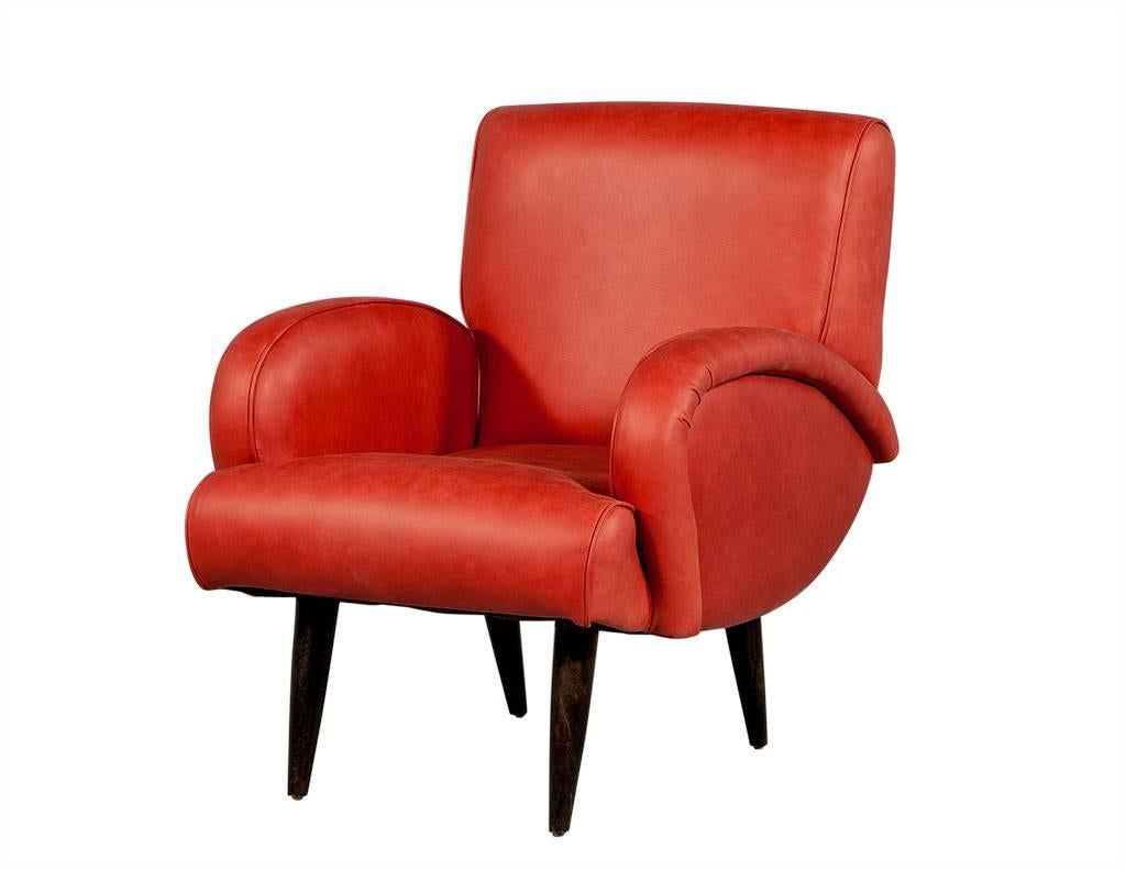 This gorgeous set of Mid-Century Modern lounge chairs is the perfect pop of the color for any living room, office, den. Made of red, distressed leather with curved arms and black tapered legs, these chairs are extremely comfortable yet simplistic in