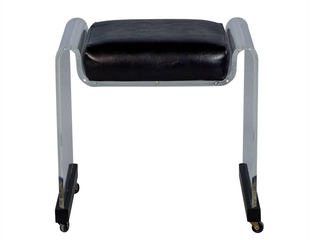 This Mid-Century Modern stool is truly a lesson in contrast. It has a waterfall Lucite frame on castors and is adorned with black trim on the base and a black vinyl seat. A cool addition to a classy office or seating area.