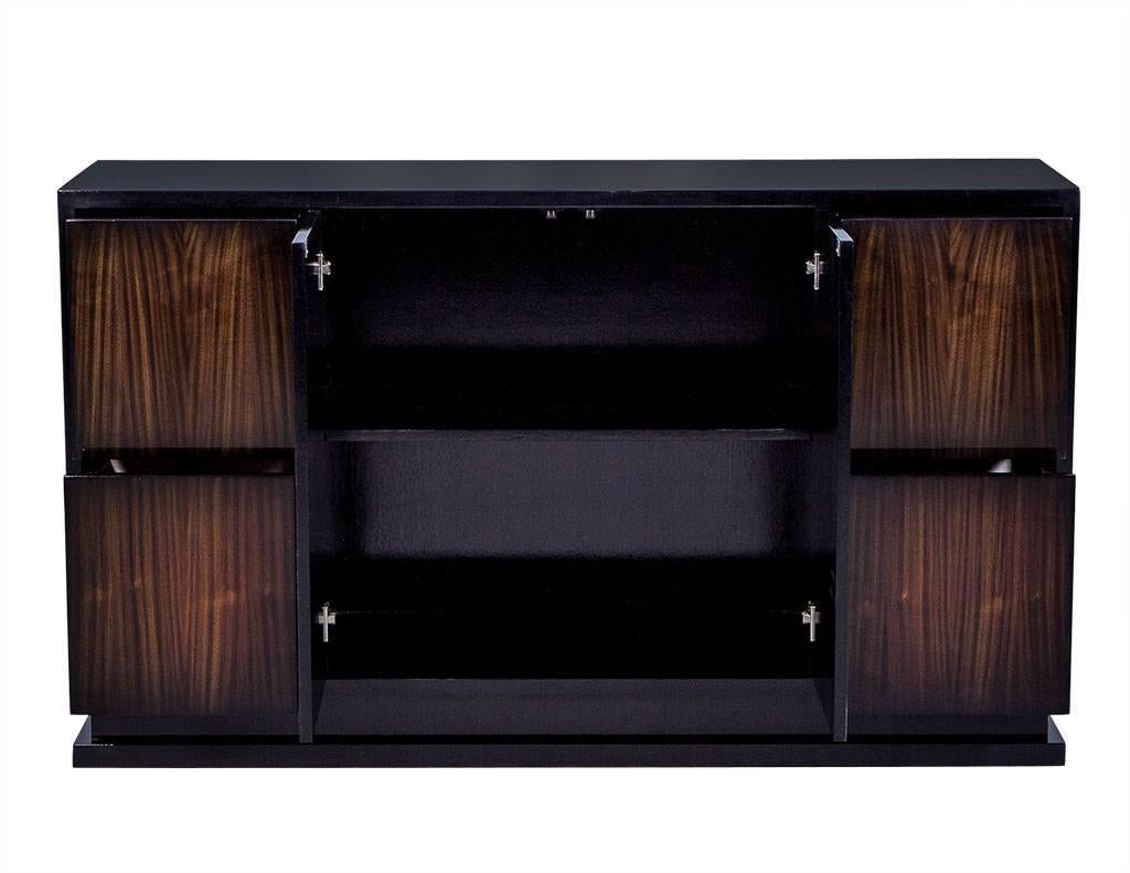 This transitional style buffet has a gorgeous, deep wood grain exterior. Crafted of walnut with two central doors and two drawers on each side, it houses two shelved compartments and sits atop a wide plinth base. A very linear look and a custom