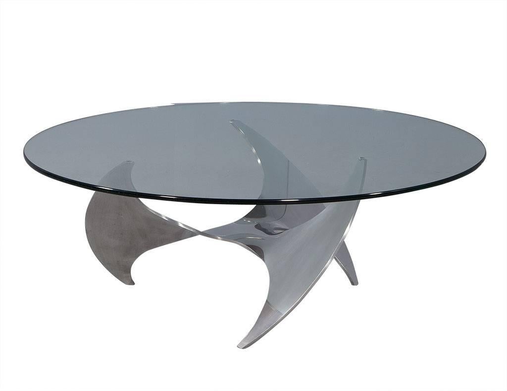 This industrial cocktail table is truly mesmerizing. Crafted in the style of Knut Hesterberg, the table is comprised of a glass top and aluminum propeller shaped base. Definitely a showstopper for any living room!