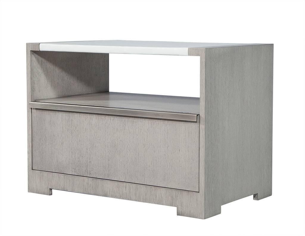 This transitional style pair of night tables is made to order out of rift cut white oak with a vinyl wrapped centre block on top. There is a lower open shelf and below that a drawer and removable back panel in wood to match. Each table is finished