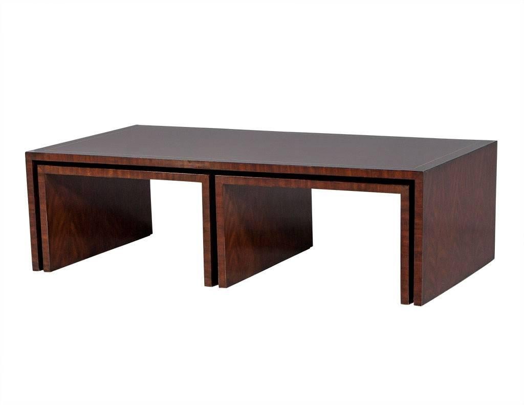 This large, transitional style cocktail table oozes trendiness. Crafted out of rich, solid mahogany and rectangular in shape, it houses two smaller nesting tables beneath the waterfall of the larger table. Each piece is inlaid with satinwood to add