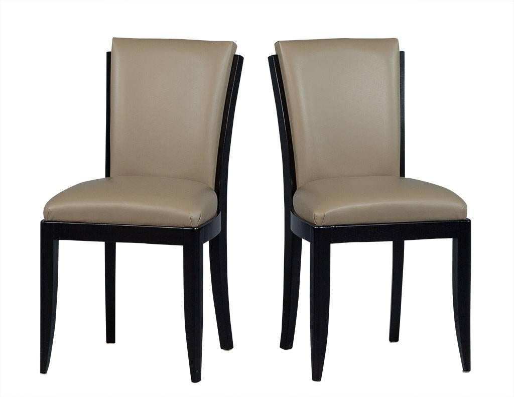 These Art Deco dining chairs are luxe yet simple. They are crafted out of a show wood frame with satin black finish and upholstered with taupe leather. Restored by Carrocel, they are a great addition to a bold dining room!