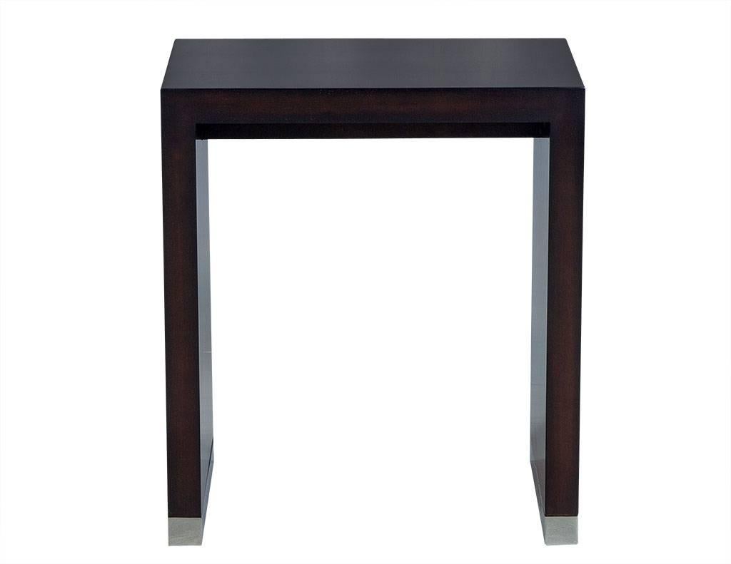This contemporary end table is absolutely gorgeous. Crafted out of mahogany wood in a waterfall style, it is adorned with stainless steel banding on the feet and a dark espresso finish. A beautiful addition to any high end living area.