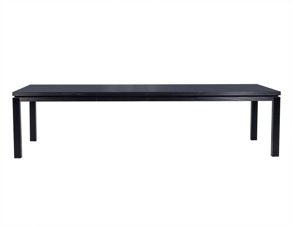 This contemporary dining table is understated yet fanciful.  It is crafted out of all black lacquered wood and comes with two leaves with ribbed edging on the entire base and legs.  A brilliant addition to any dining room!

Listed dimensions are