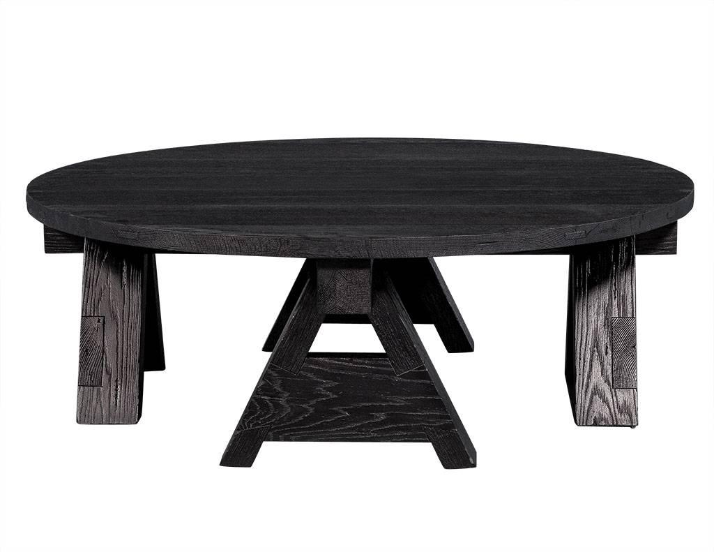 This transitional style cocktail table is truly a striking piece. The round tabletop is crafted out of sand blasted oak and sits atop four a-framed legs covered by a plank constructed top. This table comes in a black finish making it a perfect fit