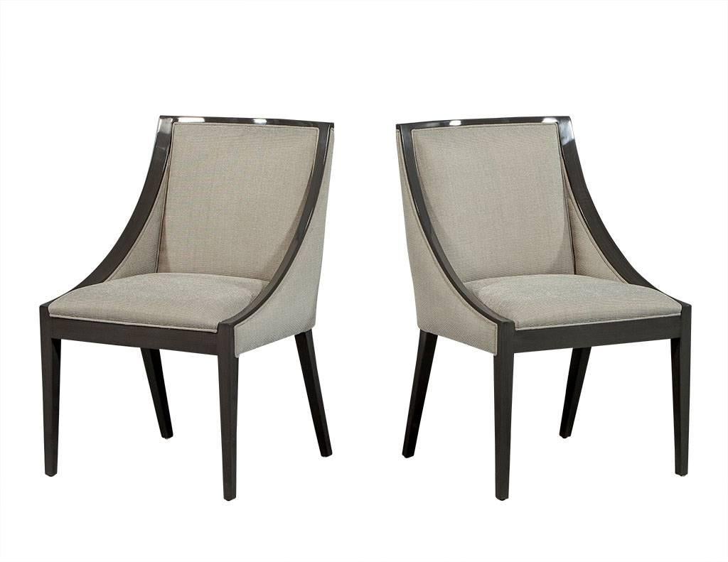 This set of Transitional style dining chairs is truly gorgeous. The show wood frames are finished in a heather grey high gloss lacquer and upholstered in a woven, textured light grey fabric. The sloped arm is a great finishing touch making these