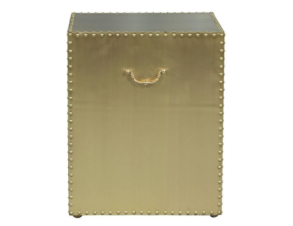 This contemporary side table is absolutely divine. The entire piece is made of satin brass adorned with nailhead trim and a matching brass handle. This table is the perfect, shining addition to a bold living space.