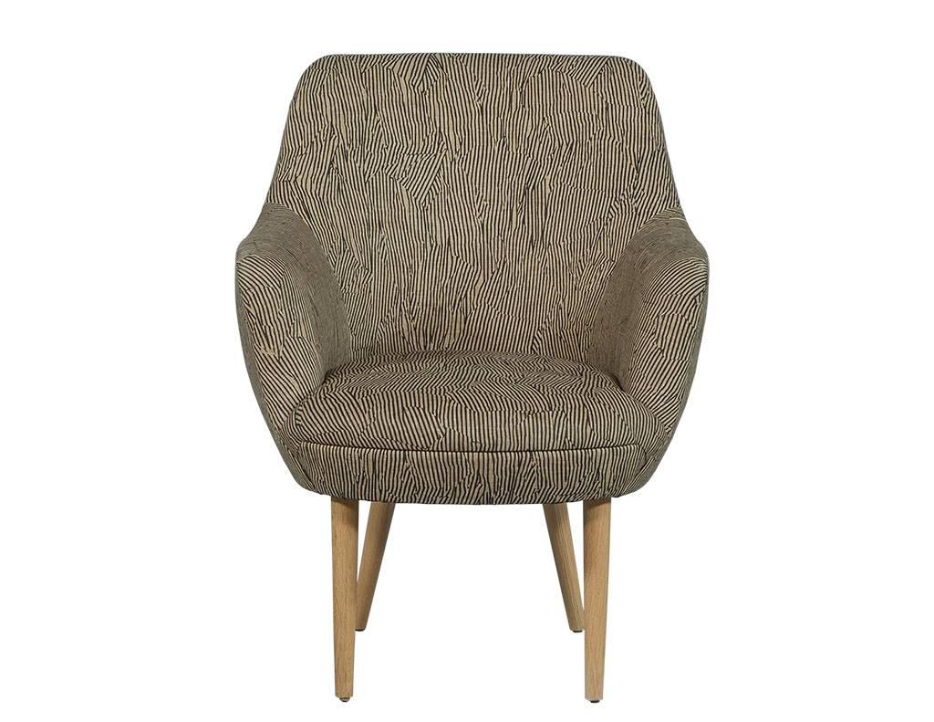 These modern armchairs have a tight back and seat with thin upholstered arms and natural oak legs that are in turned and tapered. Upholstered with Avant fabric, this chair is a chic addition to any home.
