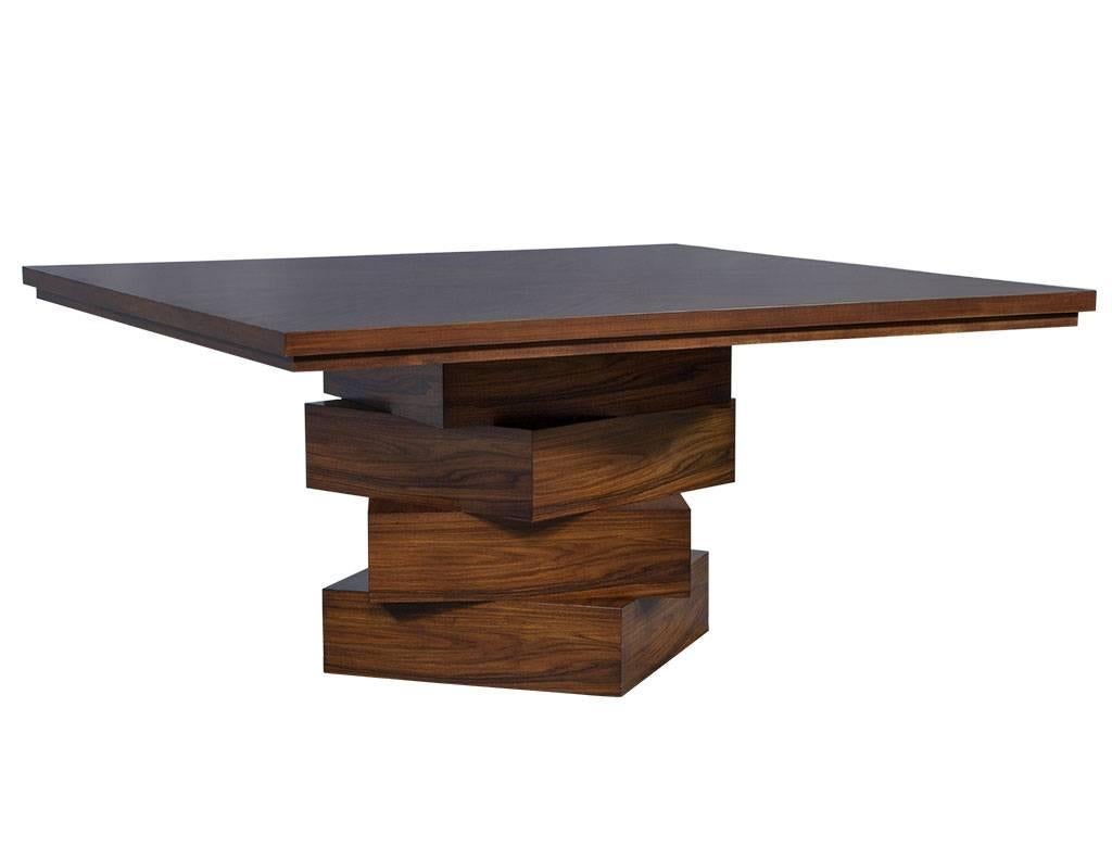This modern dining table is truly a piece of art. It is comprised of rosewood with a square top and four layered square bases. A beautiful piece for any home.