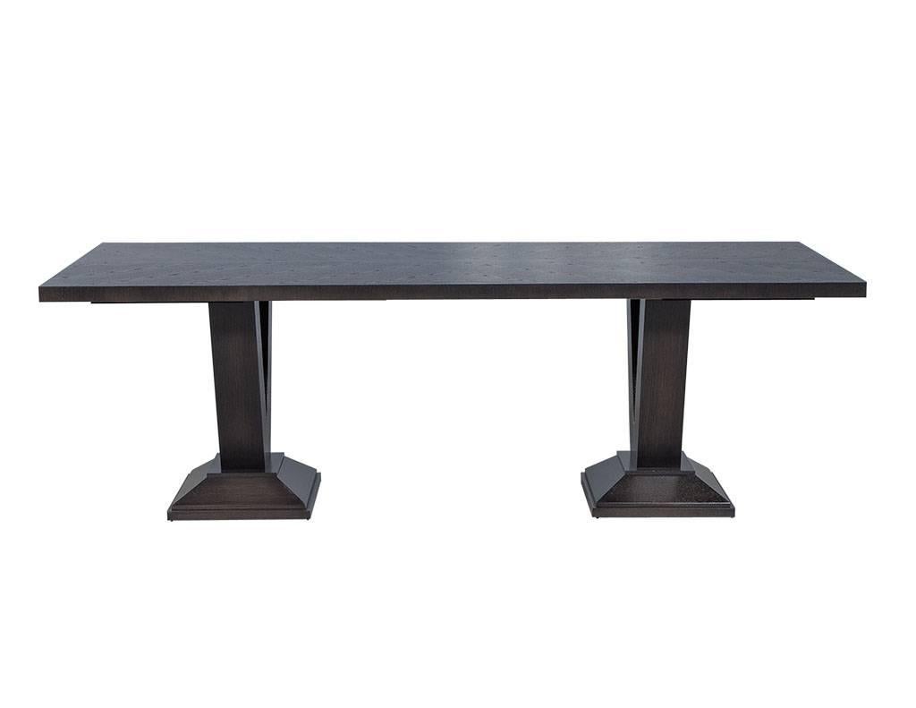 Starburst cerused oak slab top, comes with two pull-out extensions, each one 22” wide. Sits atop V-shaped double pedestal fastened to plinth bases. Finished in rich charcoal grey. Each custom table is crafted in our Canadian facility with the utmost