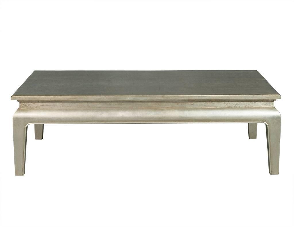 This silver leafed solid Beech wood rectangular cocktail table will add a romantic flair to any seating area. Top raised on a recessed base Resting on four tapered legs, the tabletop is supported on a recessed base and is accented with square panels.