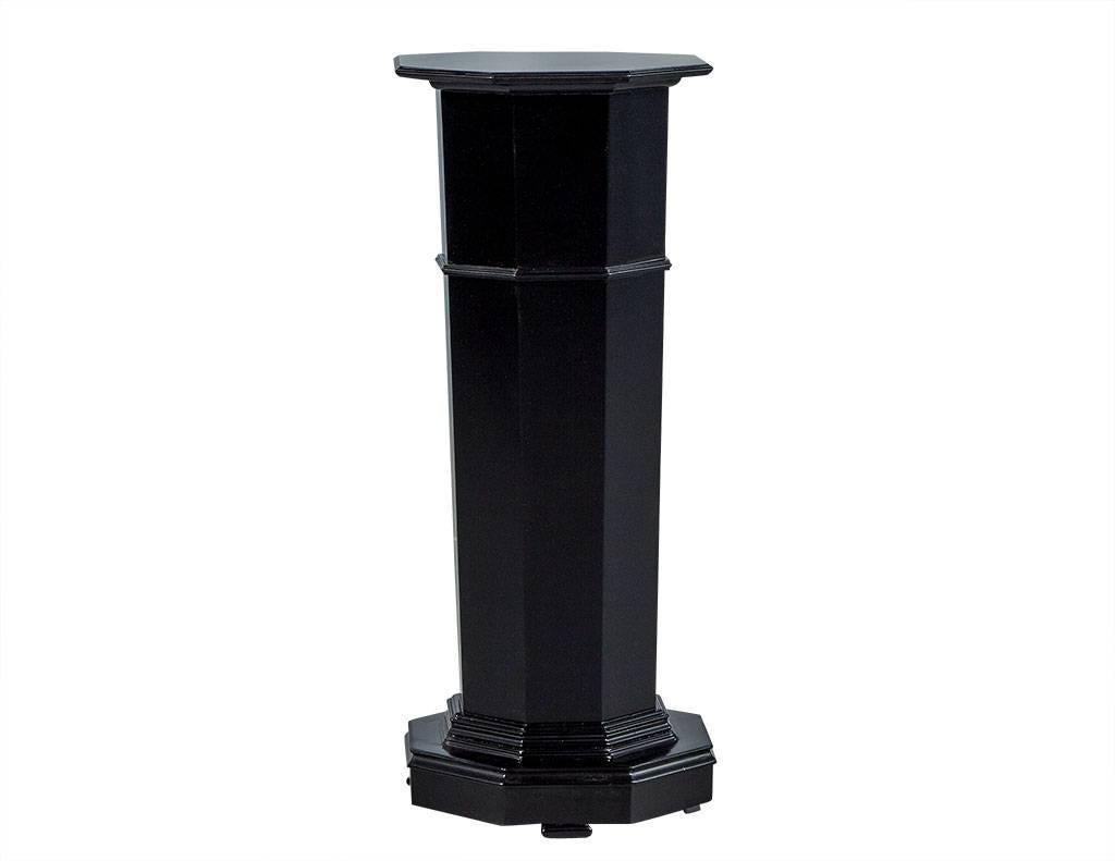 This traditional pedestal column is a gorgeous accent piece. It has a hexagonal frame with a fluted column and rests atop a craved, stacked base. The finish is a rich, matte black lacquer that adds to the sophisticated flair. A perfect piece to add