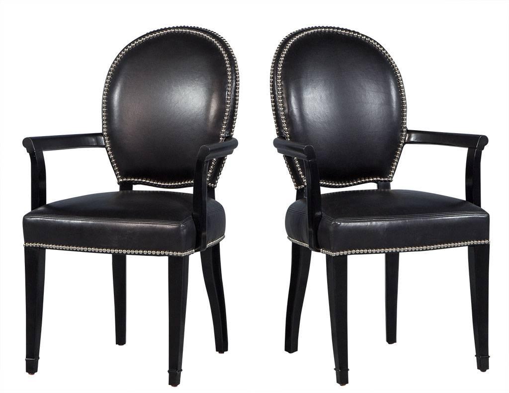 This set of dining chairs will be sure to add a luxe and elegant flair to any dining room. The rounded, curved back, black leather dining chairs are adorned with a double, polished stainless steel nailhead trim along the chair back and single along