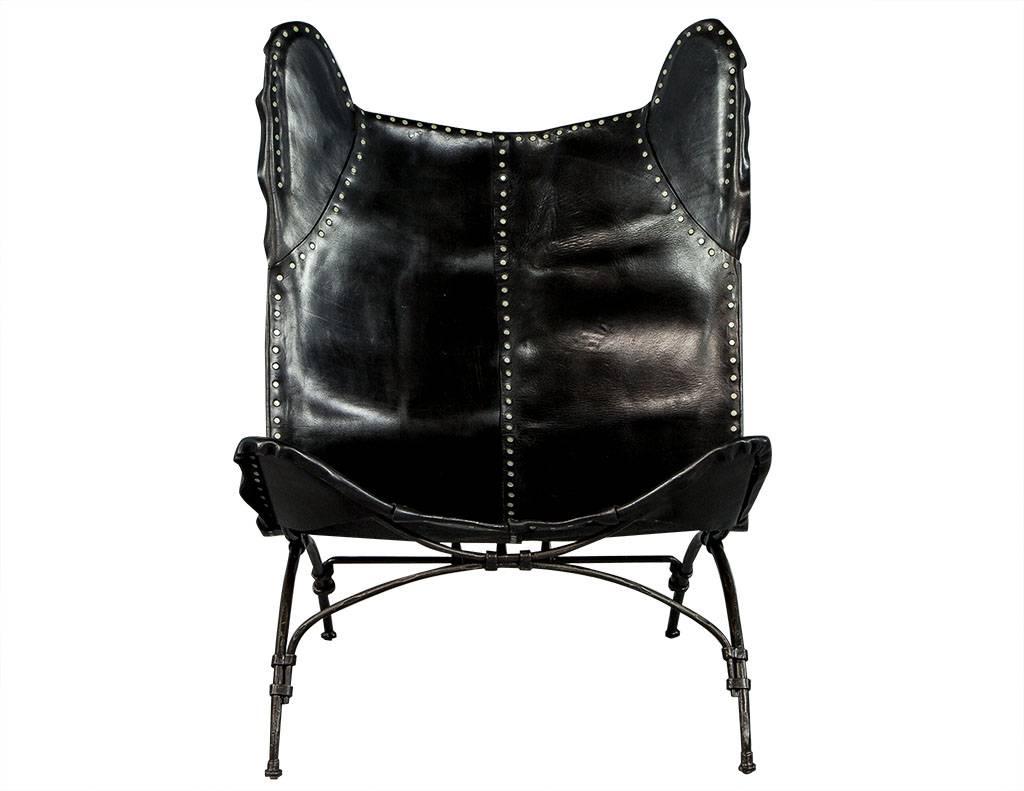 Crafted from irregularly-cut heavy saddle leather panels, this sling seat, camp chair is riveted by hand and fitted over a hand-hammered wrought iron frame and accented with a spaced-out nailhead trim. Perfect for any rustic or eclectic setting.