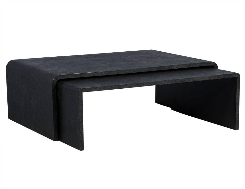 These modern nesting cocktail tables are retro and fun. They are crafted in a waterfall style and wrapped in a black-colored faux shagreen. A cool set, perfect for a daring living space.

Smaller: H 15.25”, W 46”, D 31.25”
Larger: H 16.5”, W 49”,