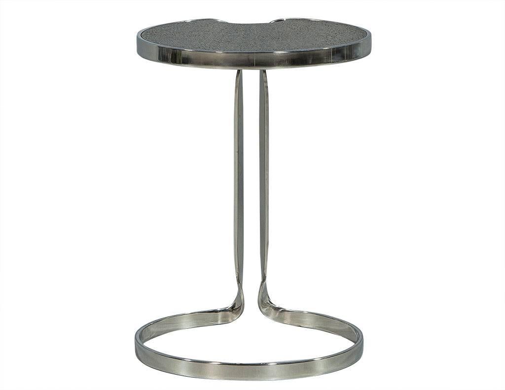This modern end table is truly special. The top is composed of a round, black cerused oak speckled with gold throughout, reminiscent of a lilly pad! The fun design is framed in flat bar and sits atop a seamless, polished stainless steel base. A