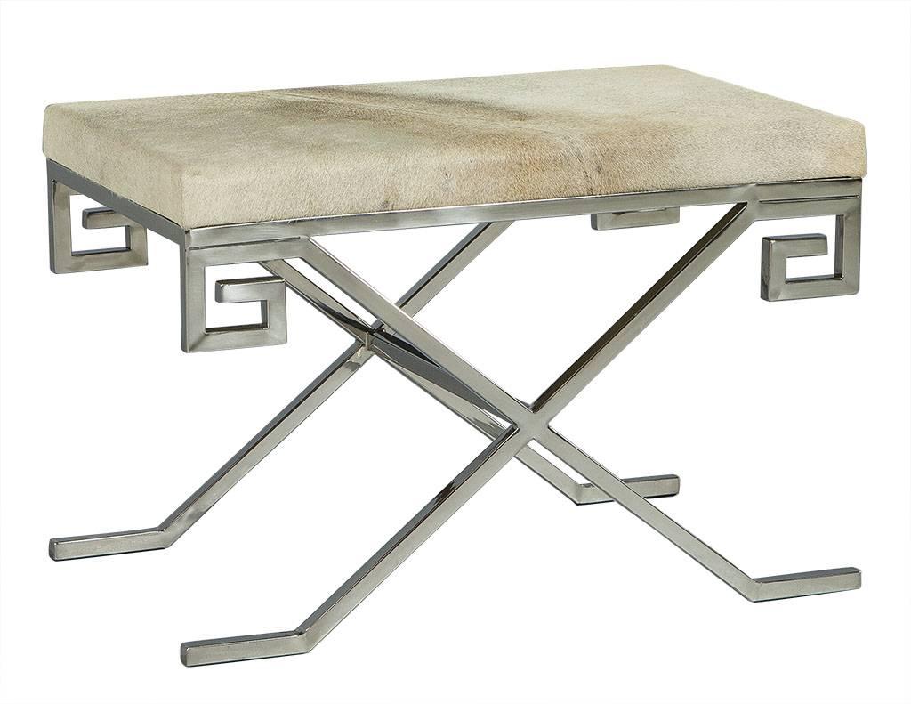 These modern stools are absolutely elegant. They each have a grey cow hide top with a Greek key designed, X-base, stainless steel frame. A perfect set for a richly designed home.