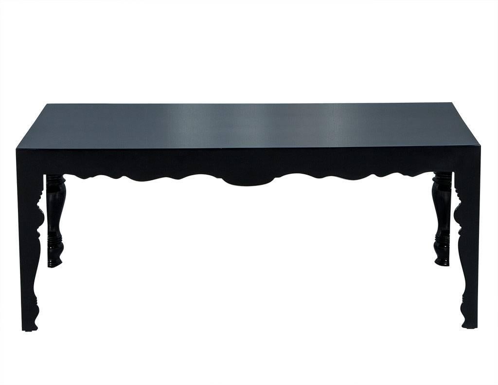 This traditional style cocktail table is just lovely. It is finished in a high gloss black lacquer with clean exterior lines while the underside and interior of the table is ornately carved in a traditional fashion. A perfect addition to a pretty