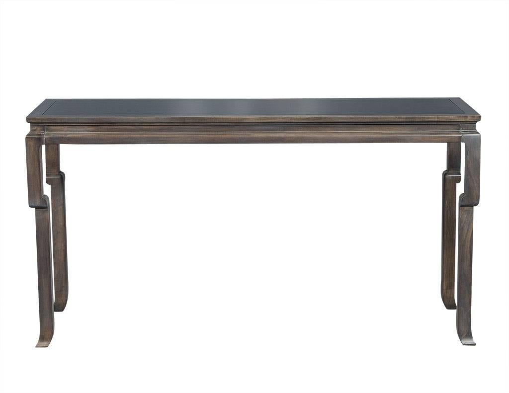 This chinoiserie console table is fabulous. It is made in the manner of a Classic Chinese altar table and is crafted out of solid maple finished in an antique grey finish. The top has a black lacquered inset field, adding more to the character and