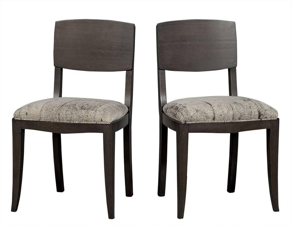 These Art Deco style dining chairs are sleek and stylish. They are crafted out of a show wood frame with a square back and refinished in a grey satin stain. Re-upholstered in textured light grey fabric, this set is gorgeous, perfect for an erudite