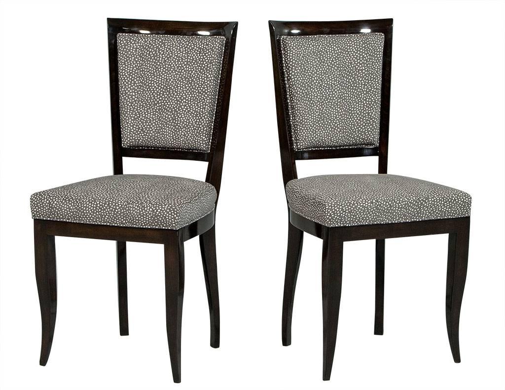 These Art Deco dining chairs are a treat for the eyes! They are fully restored and sit atop the original Art Deco frames with a high, show wood back and sabre legs. They are finished in a high gloss, dark mahogany finish stain, with the inside seat