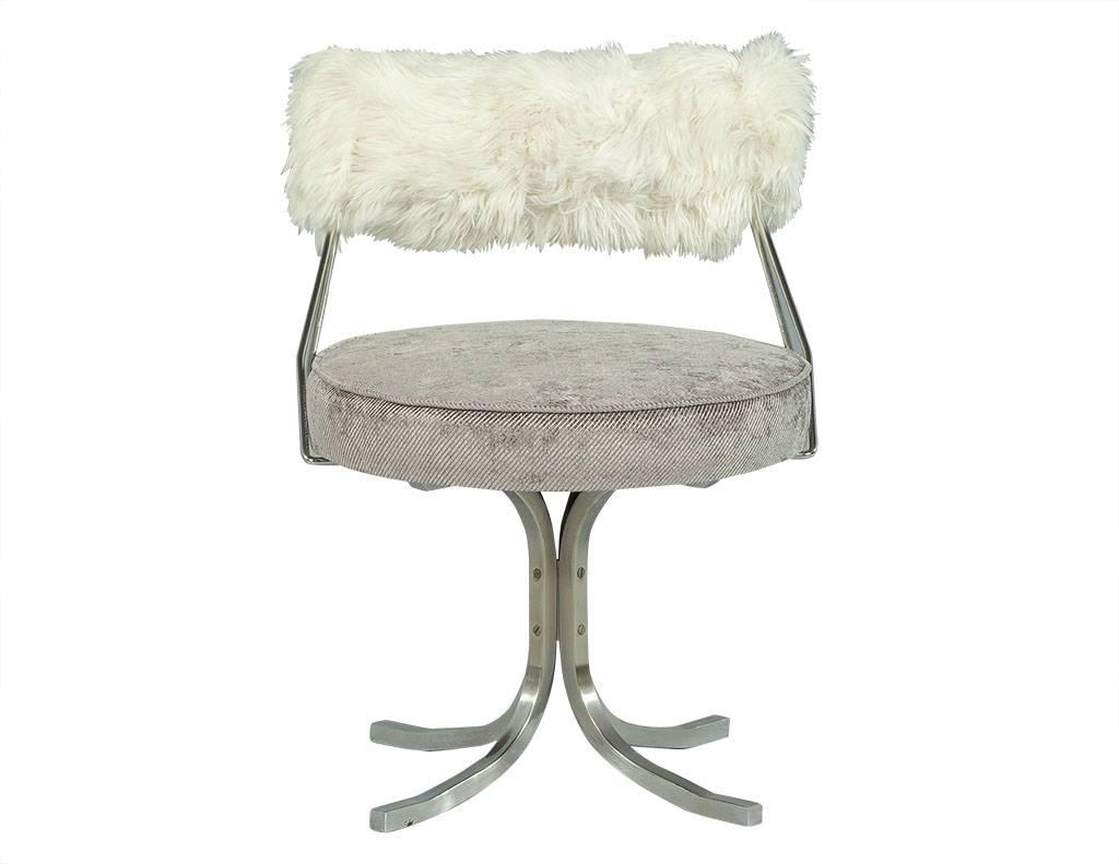 This Hollywood Regency style vanity stool is stunning. It is comprised of a vintage brushed stainless steel framed chair with four legs connected at the centre and a round seat newly re-upholstered in a pale lavender corduroy fabric. The best part