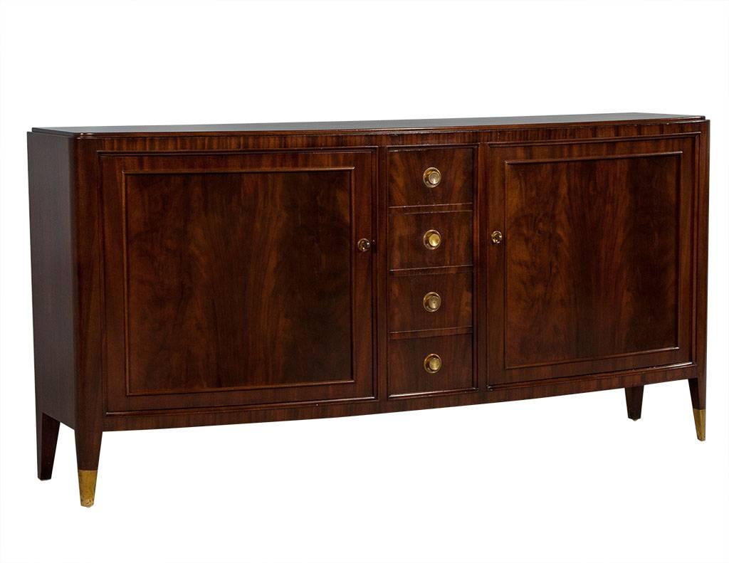 This Art Deco style buffet is the perfect mix of traditional and modern charm. A large piece, it is crafted out of rosewood with two doors at each end, interior shelves and four central drawers accented with round, copper handles. The front has a