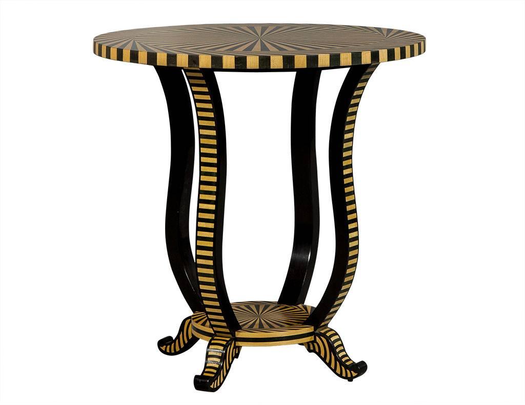 This Art Deco style accent table is a work of art! It is comprised of a round wood top and petite bottom shelf with a dark brown and blonde alternating spiral pattern that continues down the four, curved, cabriole legs and their parquetry veneers.