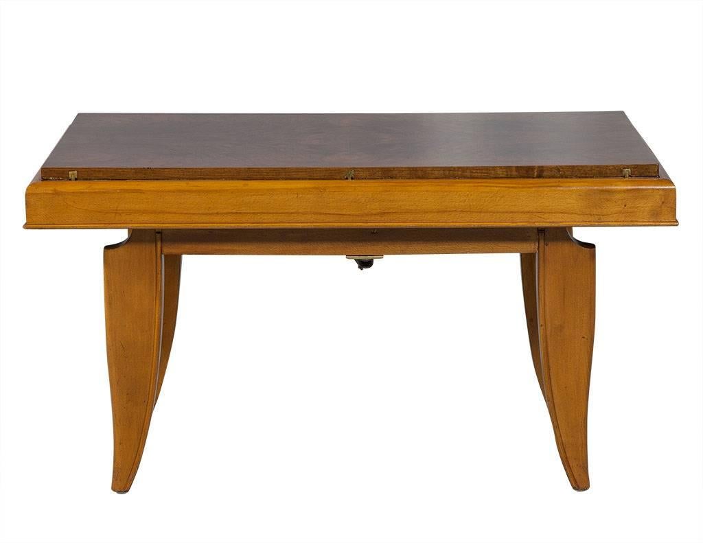 This Art Deco style cocktail or dining table is a truly amazing piece! The table is crafted out of solid cheerywood and folds to be either coffee table or dining table height. The tabletop is made of bookmatched African mahogany, all in a light