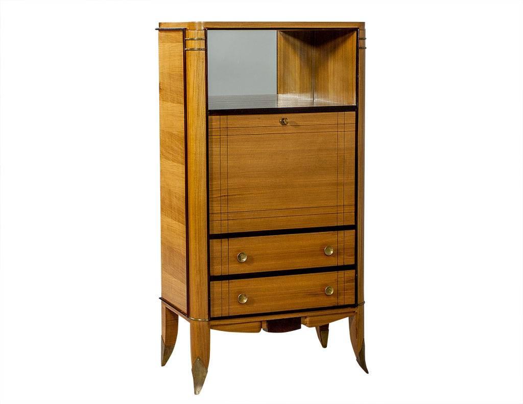 This European walnut Art Deco style highboy is delightfully French. The top is an open shelf with a mirror at the back, and beneath is a drop-down leaf with mirrors on all sides. The bottom half is comprised of two drawers and the piece is adorned