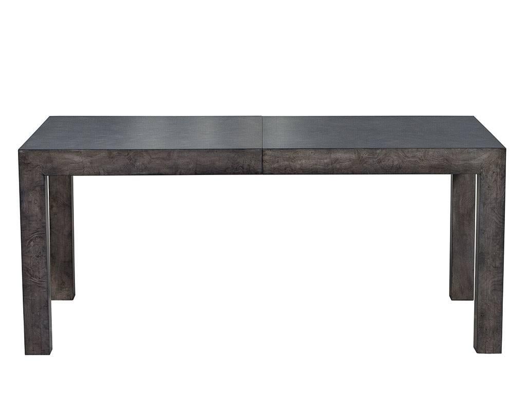 A classic Milo Baughman piece re-envisioned in a smoky grey finish, and consisting of burled wood harnessed into the linear geometry of a dining table that is. The grain of the wood infuses character to the simple natural tone surface resulting in a