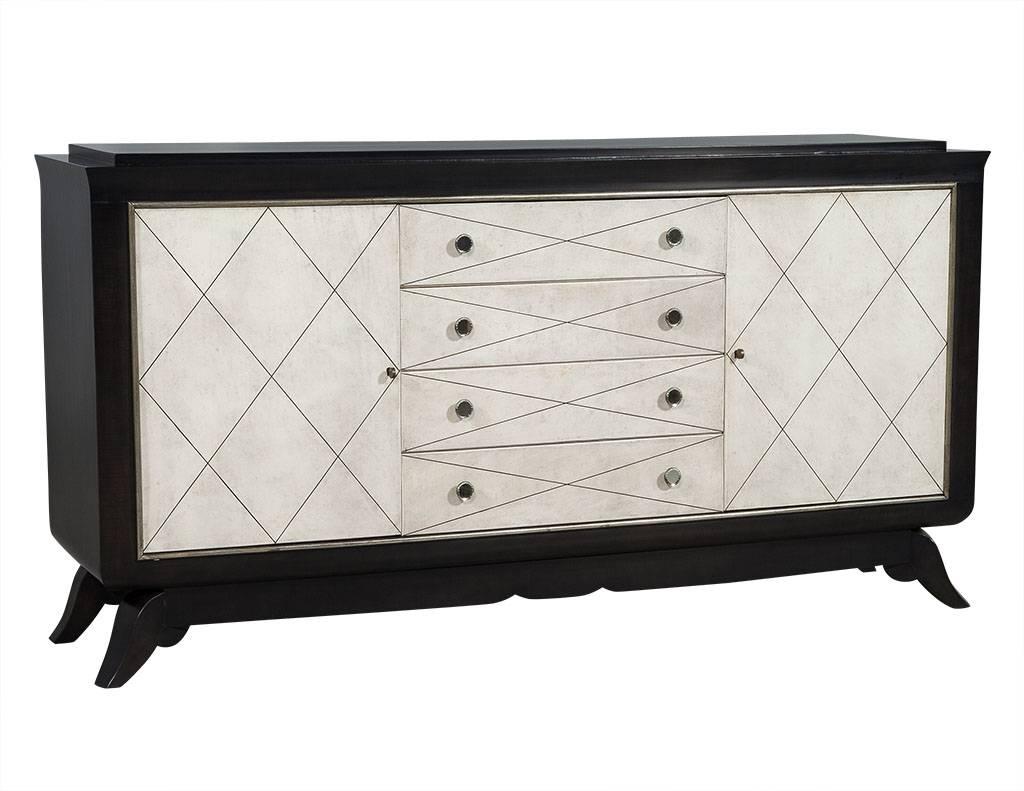 This Art Deco style credenza is a lesson in contrast and true panache. Hailing from France, this piece is part of the Carrocel Revival collection and is in excellent restored condition. The face of the piece showcases dove white leather clad drawer