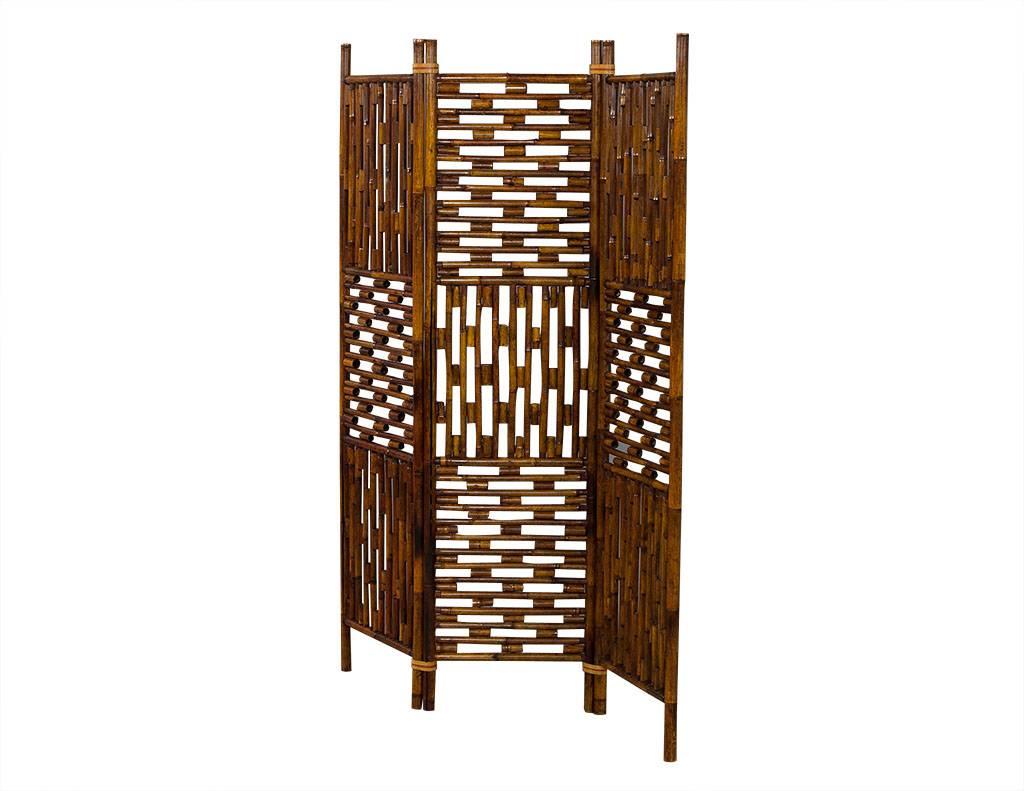 Three panelled room divider composed of bamboo with three panels with alternating vertical and horizontal pattern. Finished in medium walnut.