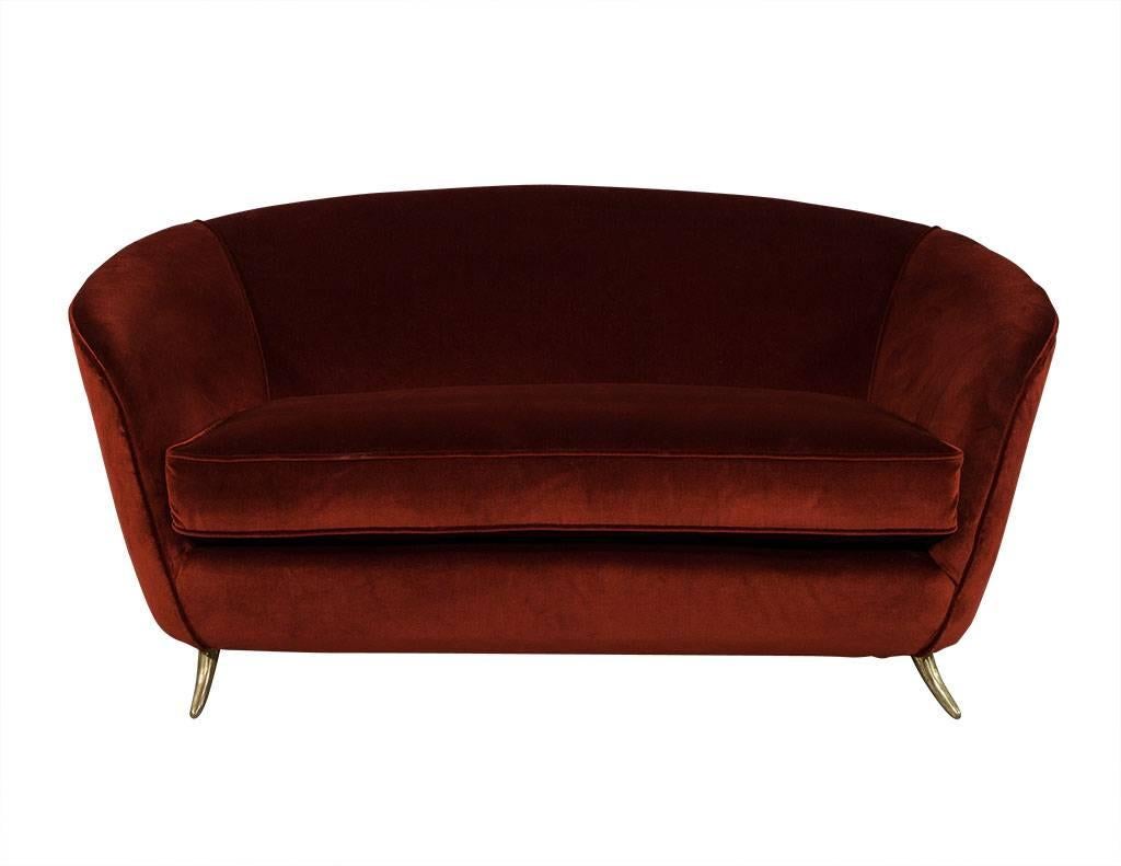 This Mid-Century Modern settee has been recently reupholstered and restored, from the low, curved back to the four tapered brass feet. A stunning piece covered in burnt orange Mohair fabric with a single cushion to add some coziness. Perfect for a