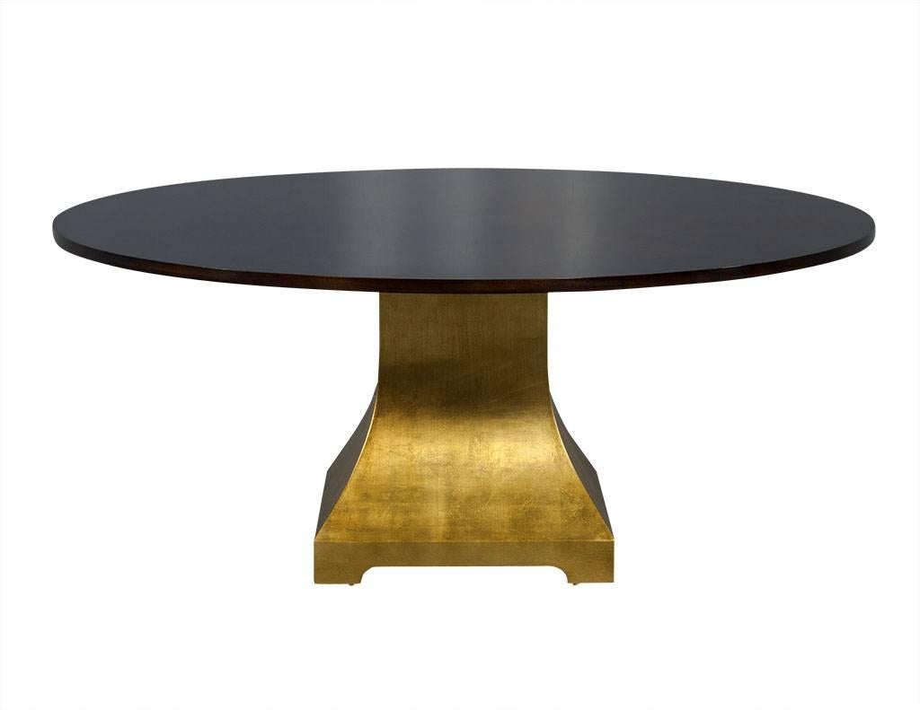 This contemporary dining table is a Carrocel custom piece. Crafted out of flamed Mahogany in a starburst pattern and finished in satin, it sits atop a pedestal of gleaming giltwood. A beautiful addition to any dining room. Please inquire for more