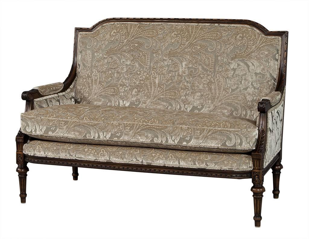 Single cushion, two seat settee with intricately carved, show wood frame finished in dark walnut stain. Upholstered in plush, premium, floral Jab Anstoetz patterned beige velvet. Two settees available, sold individually.