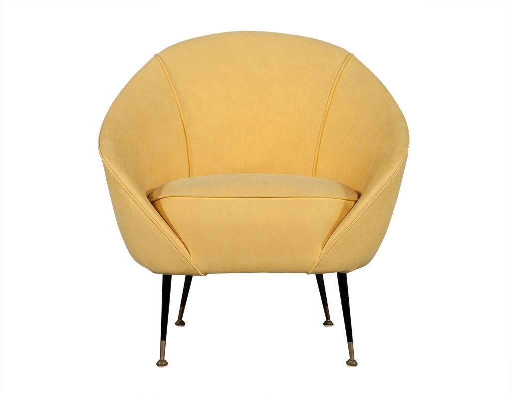 Retro crescent shaped chair in manner of Federico Munari. Low curved back with single cushion, upholstered in canary yellow velvet on thin tapered legs with brass feet tips. Matching sofa sold separately.
