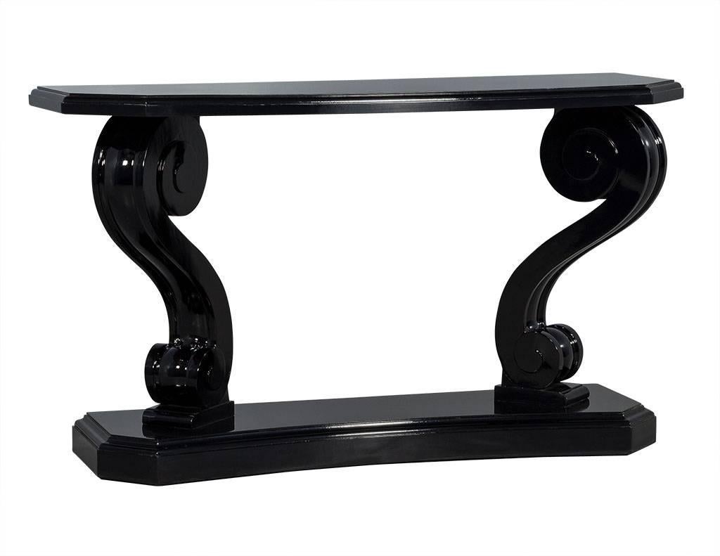 Two-tier console with chamfered corners and carved, scroll double pedestal. Finished in high gloss black lacquer.
