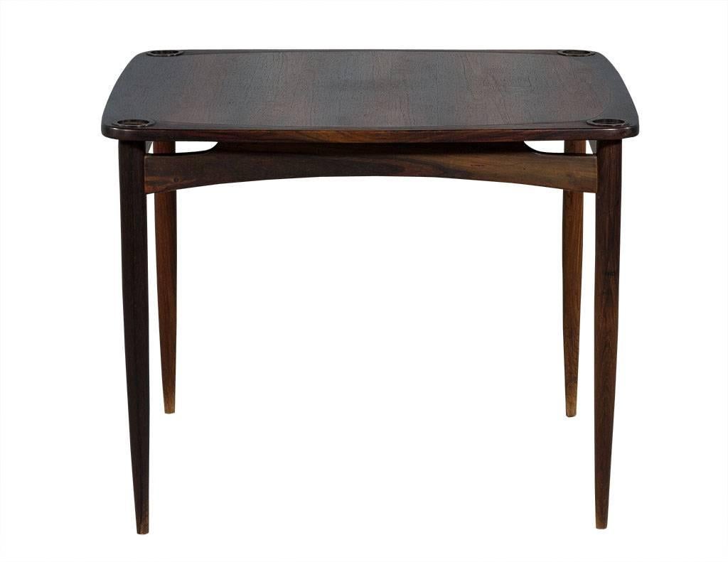 This Mid-Century Modern bridge table hails from Brazil. Crafted out of gorgeous solid woods with a square top and thin, tapered legs. The top surface is removable and the corners have round sections that sit on top of the legs. A truly stunning