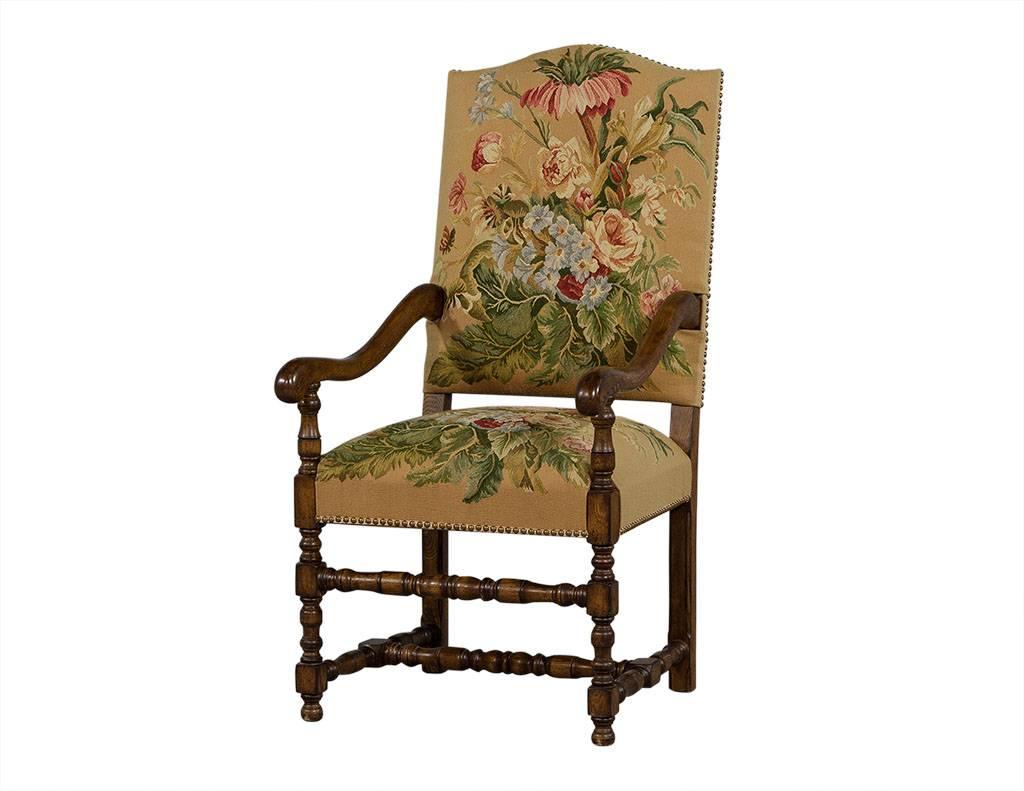 These Tudor style dining chairs hail from France and are effortlessly elegant. This set of 12 with only slight wear consistent with age and fabric in excellent condition since they are recently reupholstered. This set contains two captain’s chairs