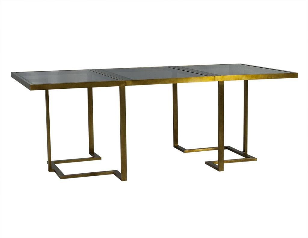 This Modern dining table hails from Italy. It is a two-piece set, composed of brass frames and smoked glass tops. They can be used as side tables or connected as a dining table with three glass sections. One table has only one glass top, while the