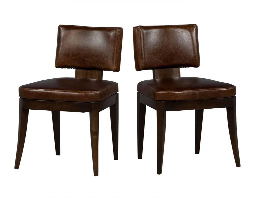 These neo deco dining chairs are rustic and beautiful. They are composed of brown distressed leather seats and backrests atop dark brown tapered wood legs. Part of the Carrocel Custom collection, this set of ten chairs can be customized for your