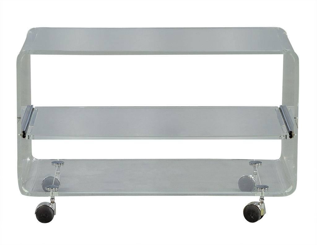 This ultramodern console cart is crafted out of acrylic, it sits atop large chrome caster wheels and has curved corners with a pull-out Lucite shelf in the middle. A great piece for entertaining, perfect for a contemporary home!