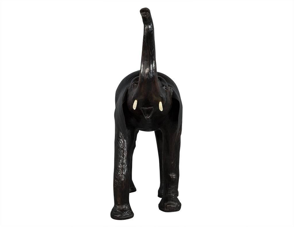 This decorative piece hails from India. A truly gorgeous sculpture, it is composed of wood with a leather skin covering and thick black leather ears with plastic (removable) tusks. Perfect for adding some global flair to any home.