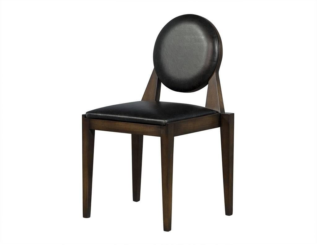 These Art Deco dining chairs are part of the Carrocel Custom collection. They are custom finished in a hand applied, highlighted, and hand rubbed walnut finish and upholstered in an aged black leather. These chairs can be custom ordered in different