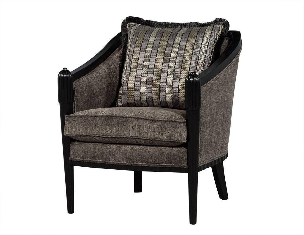 These Art Deco lounge chairs are designed by Baker. Draped in cloth fabric, each chair has black wood on the top edge of the armrests and backrest, with legs in black wood as well. Each chair also has a large backrest pillow with a three color